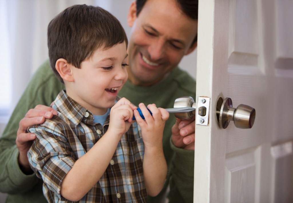 Father and son fixing doorknob
