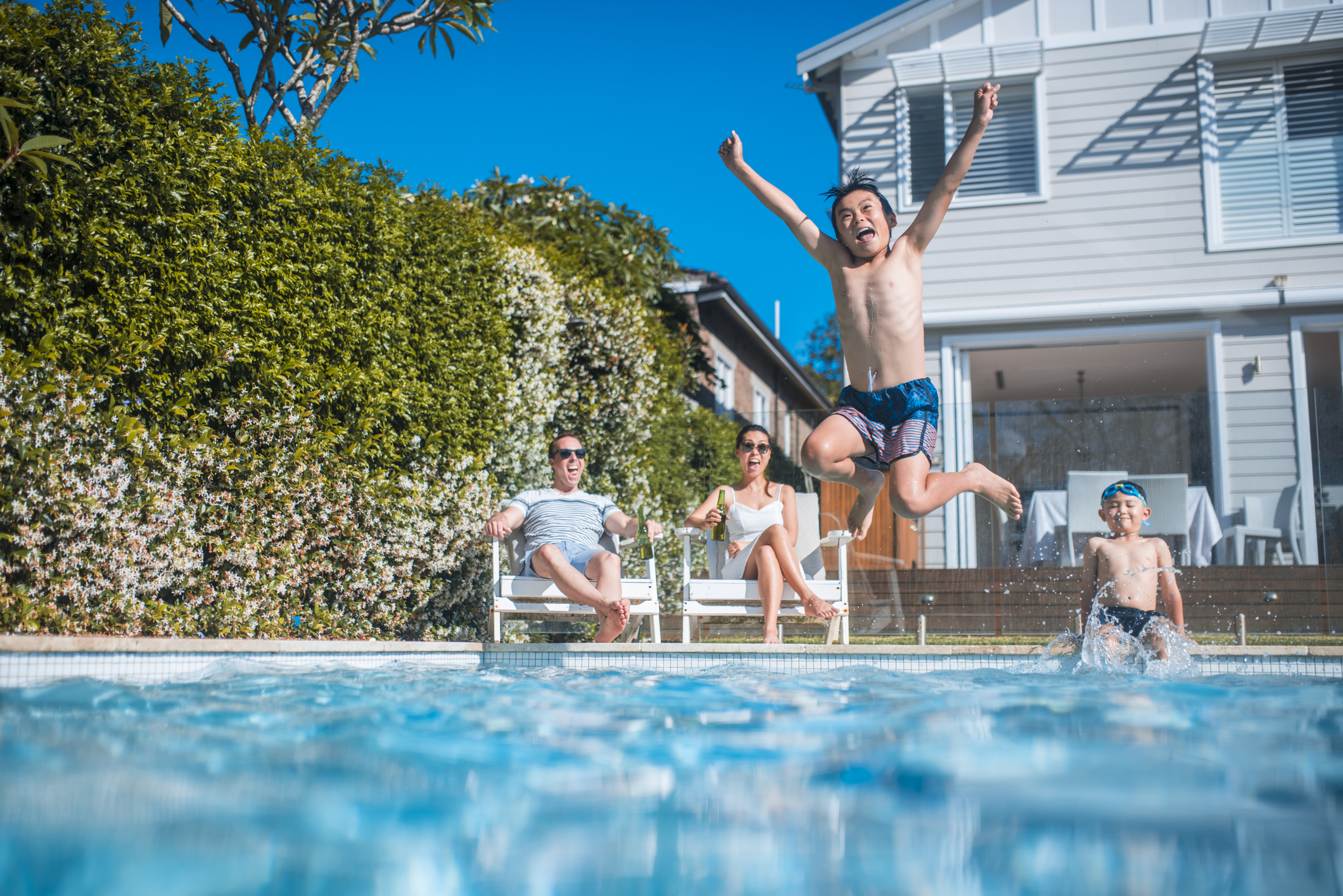Family having fun in the backyard. Kids are swimming.