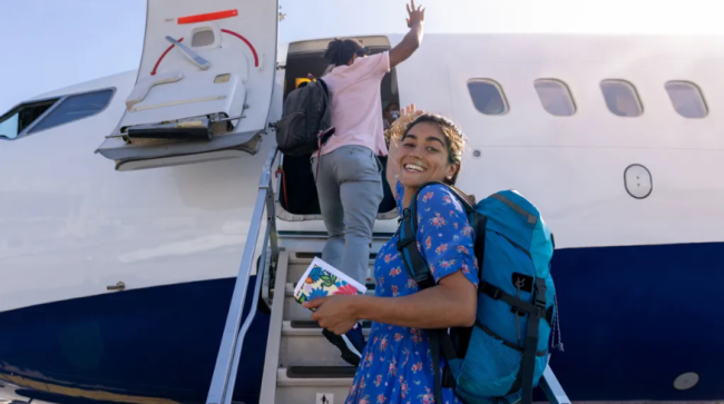 Girl boarding a plane on the runway at the airport.