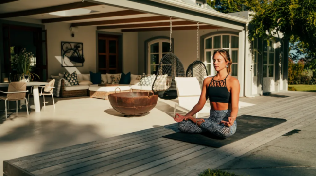 Women meditating outside her house.