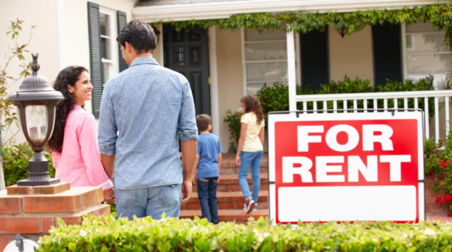 Family outside home for rent holding hands.