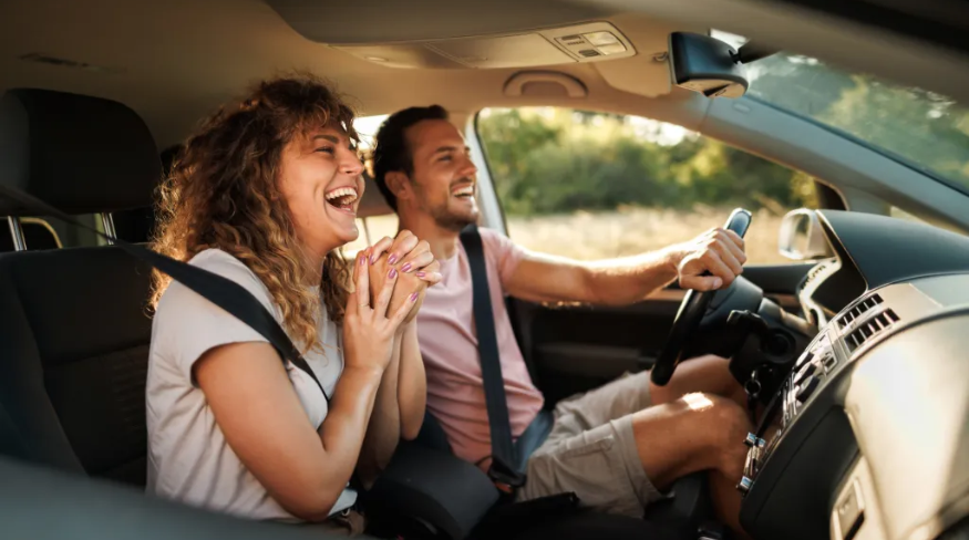 Happy couple driving in their car together.