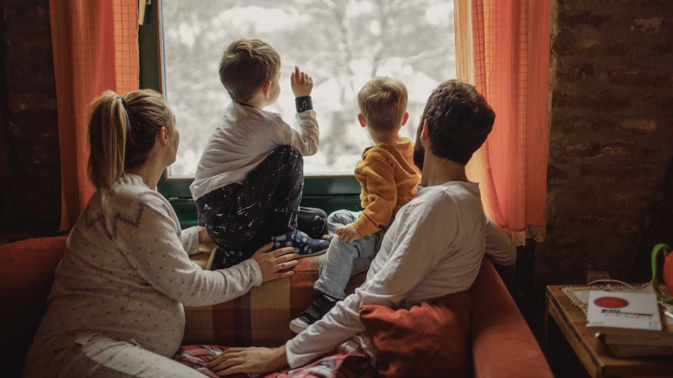 Family with two little boys, and third one on the way, being surprised by snow, early in the morning - right after waking up.