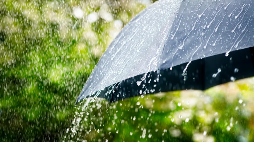 Rain drops falling from a black umbrella.